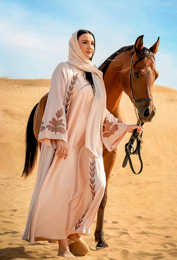 selhaya abayas - abaya wearing a woman carrying a horse in desert